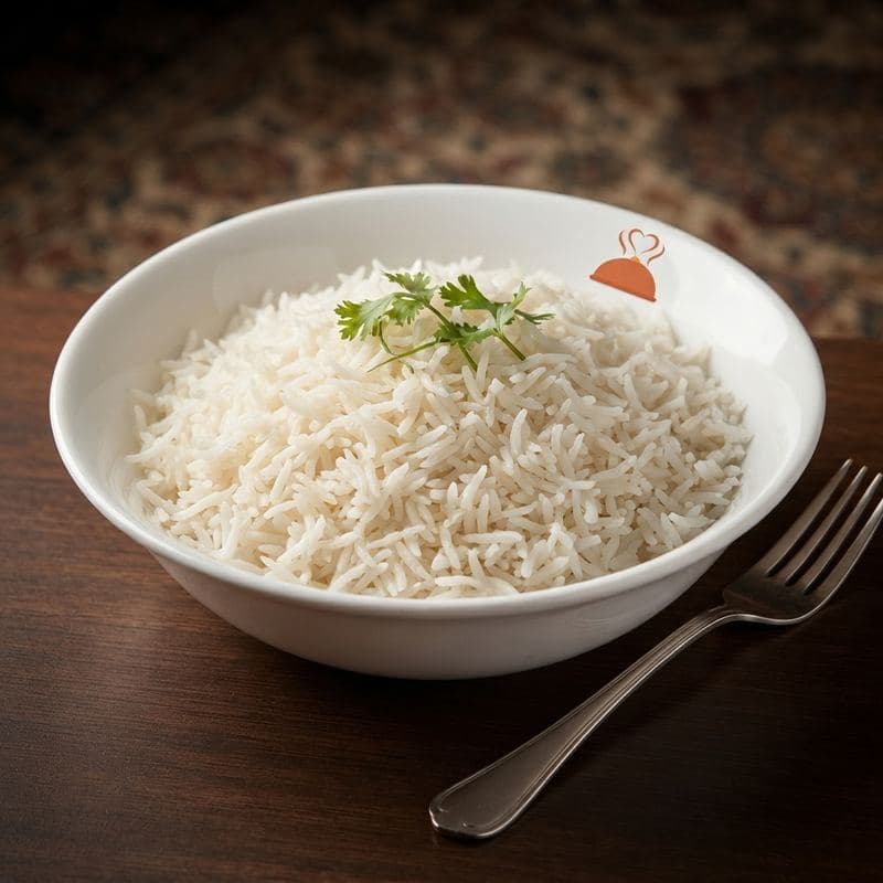 Steamed basmati rice in a white bowl with a sprig of coriander
